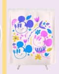 Pink mug with "Mickey Mouse" text and a shower curtain featuring colorful Mickey Mouse faces and floral designs.