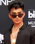 Person in black shirt and sunglasses at Billboard Music Awards 2018 red carpet.