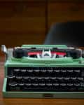 Green typewriter made of LEGOs on desk