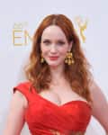 Christina Hendricks in a red dress with gold earrings at the 66th Emmy Awards.