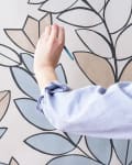 Woman painting a plant on a wall