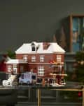Lego house set on a table in a living room with a green sofa and Christmas tree.