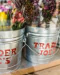 Metal buckets with Trader Joe's logo filled with colorful tulips and flowers.