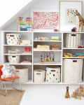 white kids' room with built in shelves with a variety of Pehr fabric storage bins