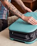 shot of someone cleaning the exterior of a suitcase.