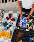 shot of someone folding clothes in a suitcase