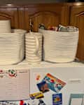 White rope storage baskets storing kitchen goods on top of refrigerator.