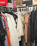 unorganized hanging clothes in closet
