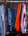 Clothes on hanger in closet before organization.
