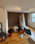 Empty living room before home staging: some rolled up rugs, power tools, etc