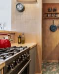 kitchen with pegboard walls, tile backsplash, and butcher block countertops