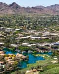Aerial view of Scottsdale, Arizona, featuring golf courses, residential areas, and distant mountains.