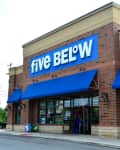 Brick storefront of Five Below with blue awnings and a $5 product display outside.