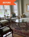 Living room with a light-colored sofa, patterned rug, glass coffee table, and armchairs by large windows.