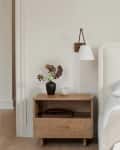white fabric head board, light wood nightstand, bed sconce, cream linens