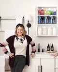 Joanna Teplin and Clea Shearer of The Home Edit with an organized, colorized medicine cabinet in a bathroom with white cabinetry