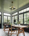 Sitting room painted in green by Jean Stoffer with a wooden dining table and gray and cream checkerboard floors