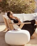 Leanne Ford sitting on a white and natural wood outdoor sectional sofa