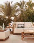 Teak and cream upholstered outdoor sofa, ottoman, chair, and coffee table from the CB2 and Ross Cassidy collection