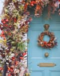 Floral arch around light blue front door