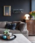 a living room with a black wall and gray sofa