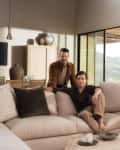 beige sectional couch with wall of windows and dark brown accents
