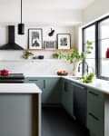 White kitchen with green cabinets below and open shelving above the counter