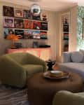 Records hung on picture ledge above sideboard in living room with seating and disco ball.