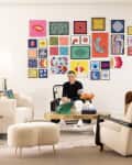 Gallery wall behind tan furniture in living room, Jonathan Adler in chair