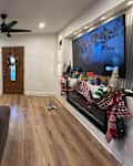 White living room with white sofas and TV on wall with shelves and fluted accents after makeover