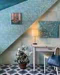 Two types of Van Gogh inspired wallpaper on a wall with angular architecture with a white desi in front of it