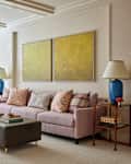 Table lamps flank pink sofa in cozy decorated apartment living room.