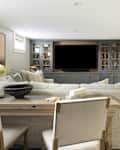 Neutral toned living room with console table and chairs behind the sofa