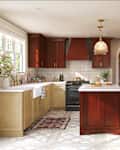 Modern kitchen featuring red cabinetry, a white farmhouse sink, and a central island with a marble countertop.