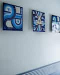 Blue art on wall of blue painted bathroom.