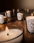 Diptyque candle collection on wooden table.