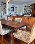 Vintage wooden dining table surrounded by chairs.