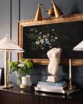dark walls, gold sconce, gold ornate frame, matching lamps, torso bust