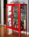 Red glass cabinet near apartment dining area.