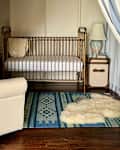 Brass crib inside tent of circus themed nursery.