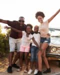 family in front of car