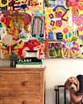 Shana Blakley iheirloom collage of kids' art on the wall with a young girl hugging a dog in the foreground