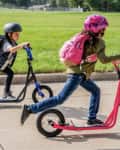 Two kids on black and pink Mongoose scooter