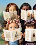 Modern American Girl dolls reading books.