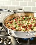 stainless steel pan holding a rice dish on stove