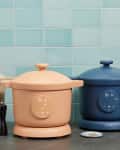 Three digital display pots in beige, peach, and blue on a kitchen counter with a light blue tiled wall.
