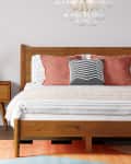 Wood platform bed and side tables in bedroom.