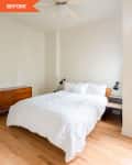 Bedroom with white bedding, wooden dresser, black wall lamps, and ceiling fan.