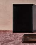 Two dark wooden cutting boards on a textured surface, one with a quince.
