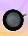 Non-stick frying pan with a long metal handle on a pastel gradient background.